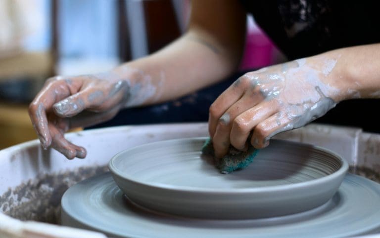 Hænder drejer en keramik skål